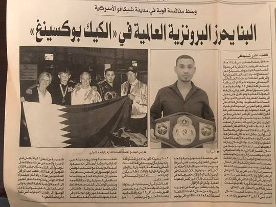 An Arabic newspaper page with two photographs: officials holding the Qatari flag at a reception, and Rami Al Banna holding a championship belt.
